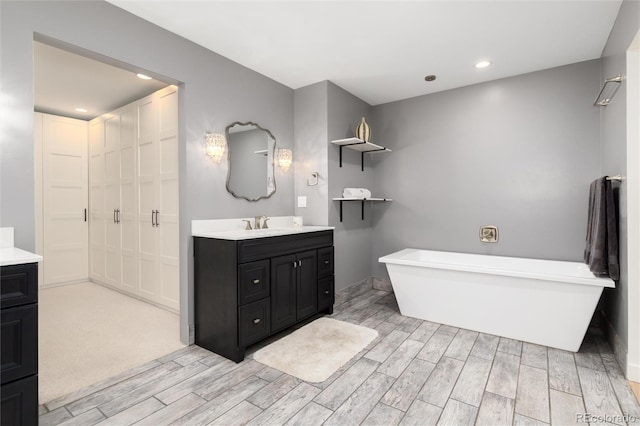 1 Club Ln, Littleton, CO 80123 - bathroom with vanity, wood finished floors, a freestanding bath, and recessed lighting