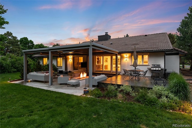 1 Club Ln, Littleton, CO 80123 - rear view of property featuring an outdoor living space with a fire pit, a chimney, a yard, a deck, and a tiled roof