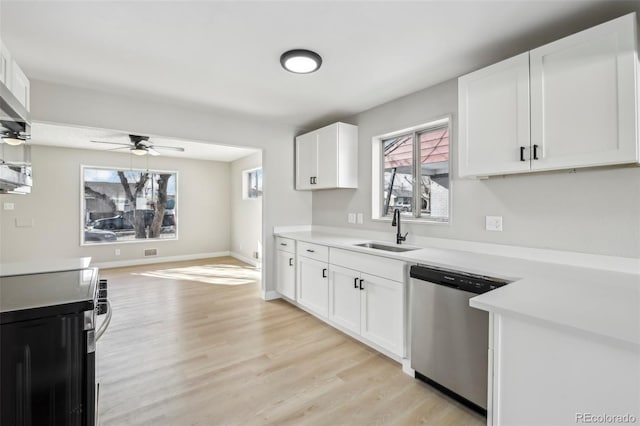 kitchen featuring stainless steel appliances, sink, white cabinets, and light wood-type flooring