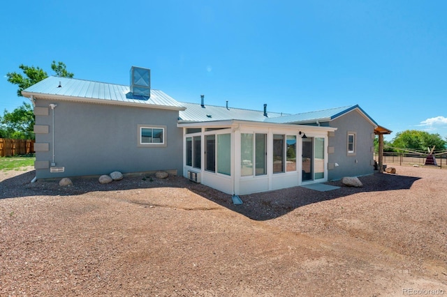 rear view of house featuring a sunroom