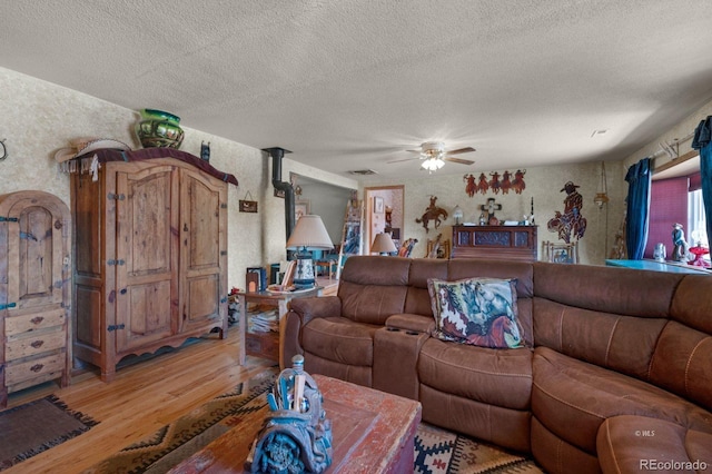 living room with hardwood / wood-style flooring, a textured ceiling, and ceiling fan