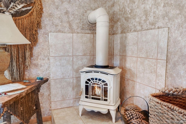 room details featuring a wood stove and tile patterned flooring