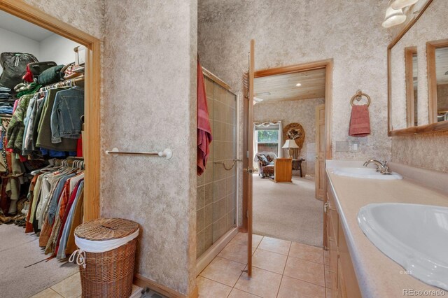 bathroom with tile patterned flooring, walk in shower, and vanity