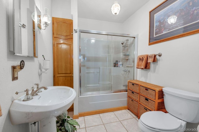 bathroom featuring tile patterned floors, enclosed tub / shower combo, and toilet