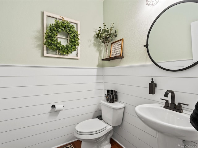 2853 Black Canyon Way, Castle Rock, CO 80109 - bathroom with a sink, toilet, a wainscoted wall, and wood finished floors