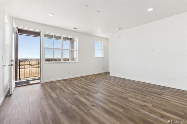 spare room with visible vents, baseboards, and wood finished floors