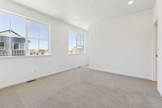 spare room with recessed lighting, baseboards, visible vents, and carpet flooring