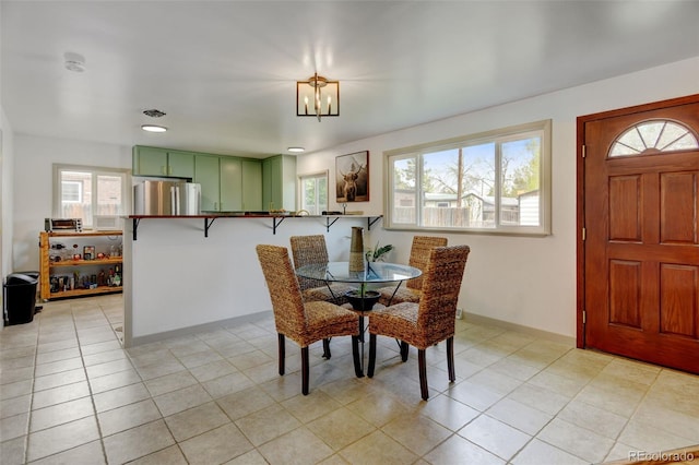 dining area featuring a chandelier, baseboards, and light tile patterned floors