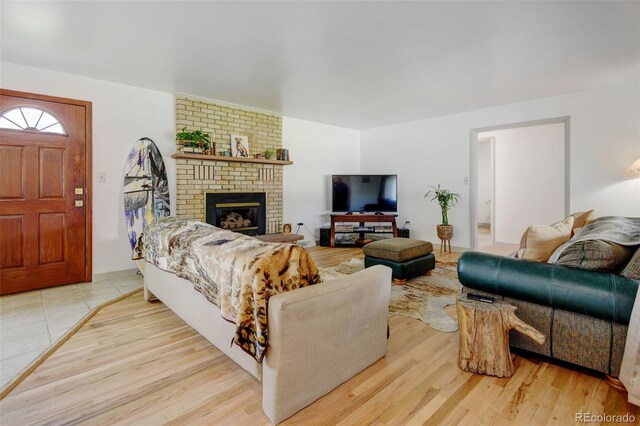 living room featuring wood finished floors and a brick fireplace