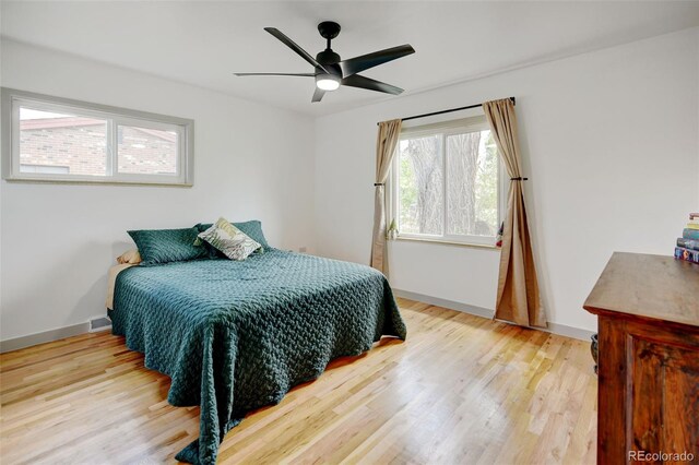 bedroom featuring wood finished floors, baseboards, and a ceiling fan