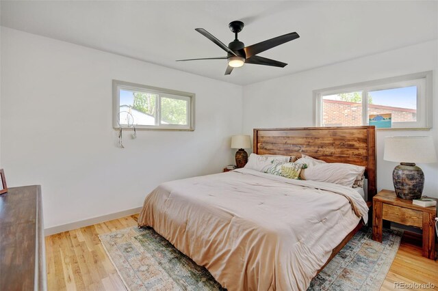 bedroom with light wood-style flooring, baseboards, and a ceiling fan