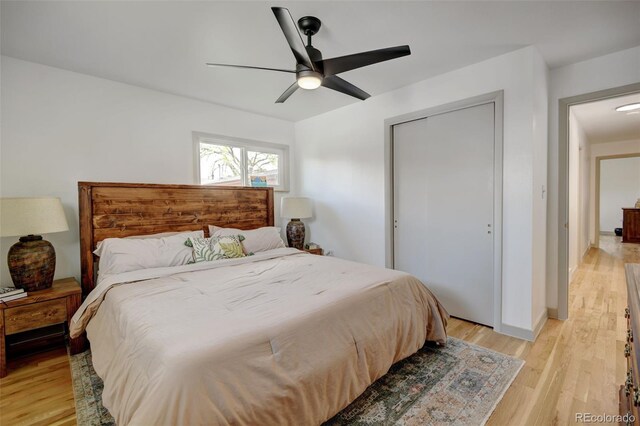 bedroom with light wood finished floors, a ceiling fan, baseboards, and a closet