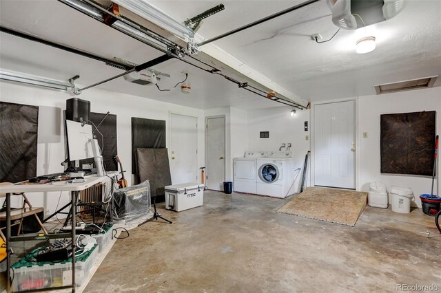 garage with independent washer and dryer and a garage door opener