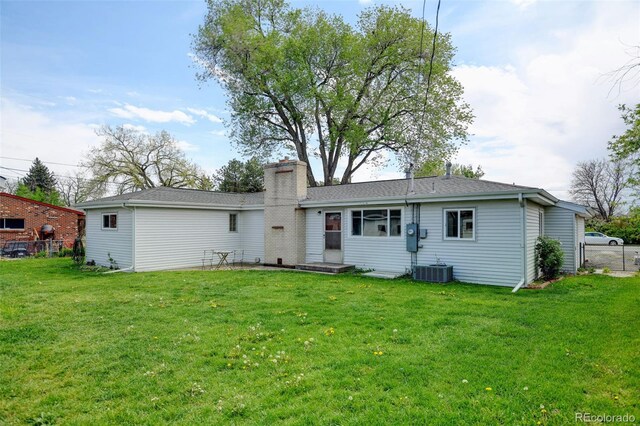 back of property featuring a chimney and central AC unit