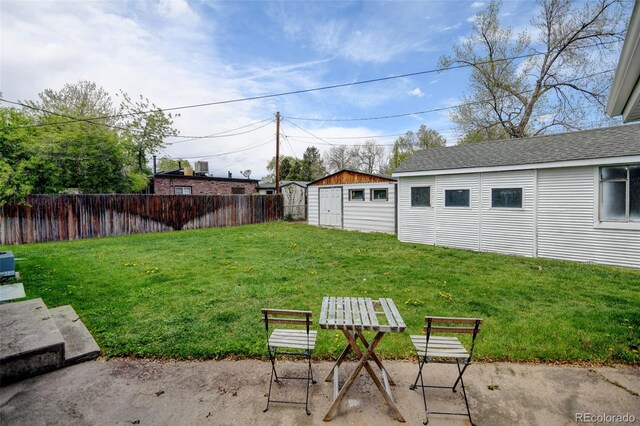 view of yard featuring an outdoor structure, a patio area, and a storage unit