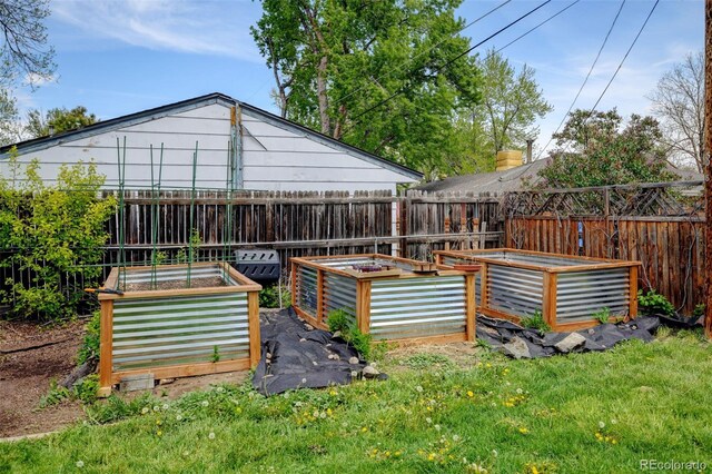 back of property with a vegetable garden and fence