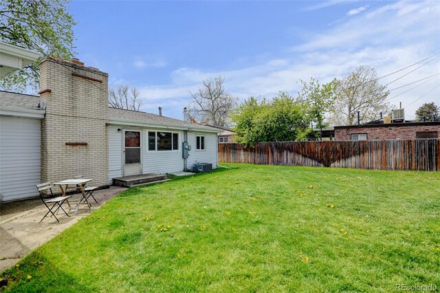 view of yard with central air condition unit and a patio