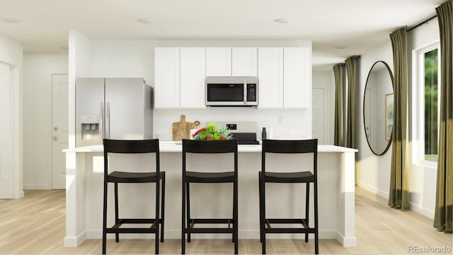 1159 Redfish Pt, Colorado Springs, CO 80904 - kitchen featuring white appliances, light wood-style floors, a kitchen breakfast bar, and white cabinetry