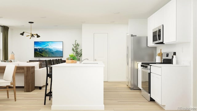 1159 Redfish Pt, Colorado Springs, CO 80904 - kitchen with stainless steel appliances, light wood finished floors, white cabinetry, and light countertops