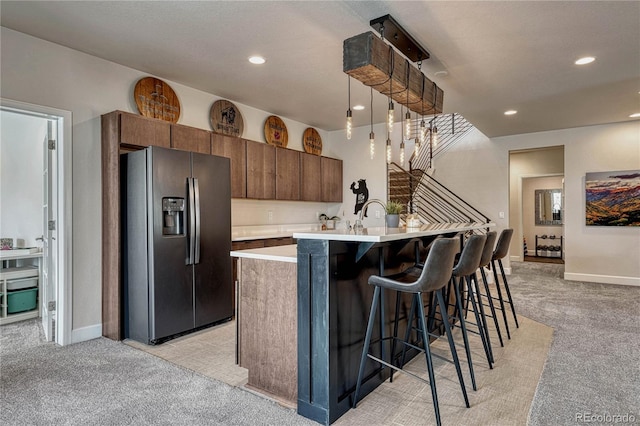 5251 Silver Hare Ct, Castle Rock, CO 80104 - kitchen with light colored carpet, a breakfast bar, light countertops, recessed lighting, and refrigerator with ice dispenser