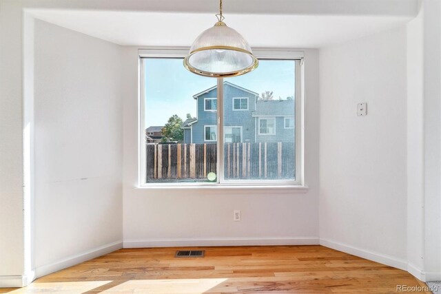 unfurnished room featuring plenty of natural light and hardwood / wood-style floors