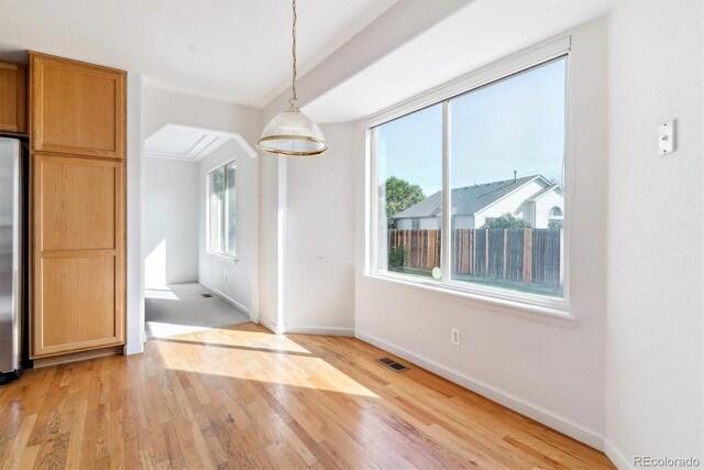 unfurnished dining area with plenty of natural light and light hardwood / wood-style floors