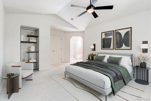 carpeted bedroom featuring lofted ceiling, connected bathroom, and ceiling fan