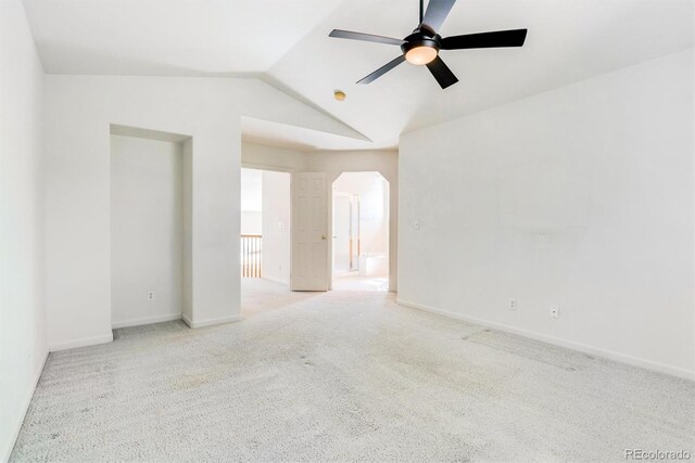 carpeted spare room with ceiling fan and vaulted ceiling