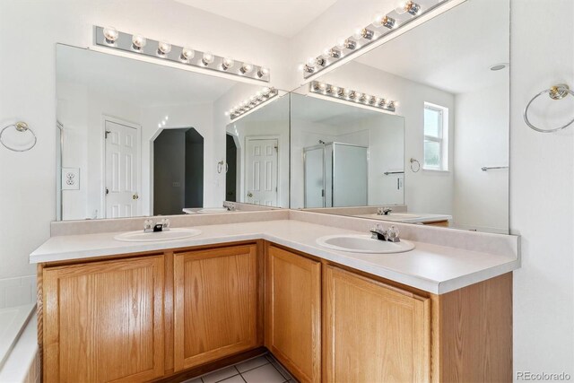 bathroom featuring tile patterned flooring, an enclosed shower, and vanity