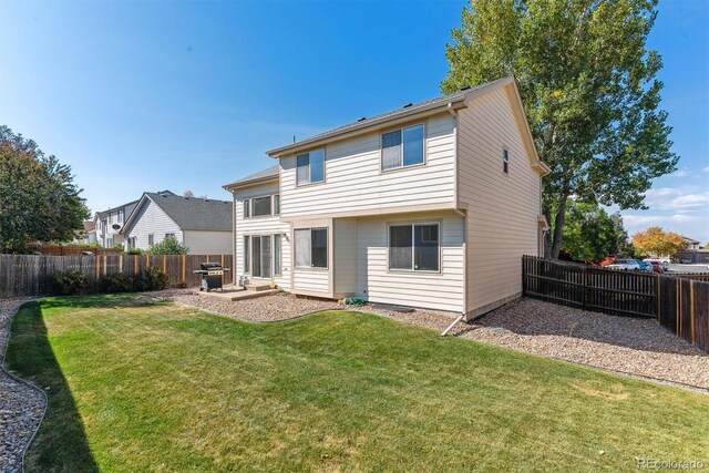 rear view of property featuring a yard and a patio