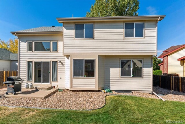 rear view of house featuring a patio and a yard