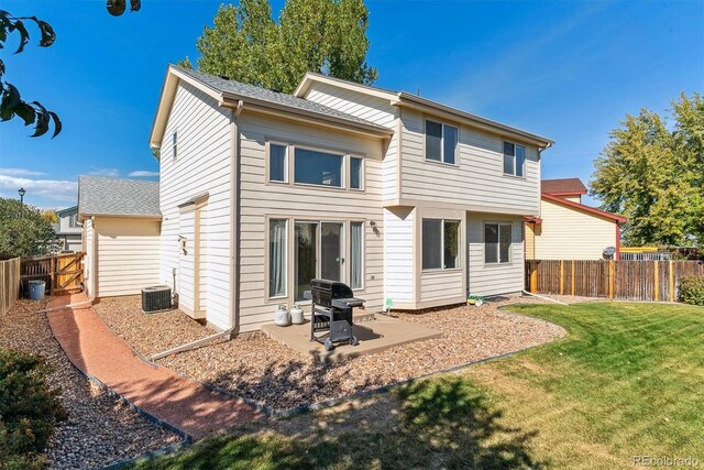 back of house featuring a lawn, a patio, and central AC