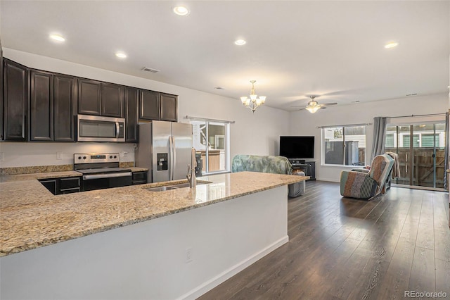 14700 E 104th Ave Unit 1105, Commerce City, CO 80022 - kitchen with appliances with stainless steel finishes, light stone countertops, dark wood finished floors, a sink, and a chandelier
