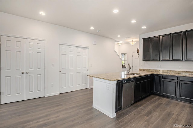14700 E 104th Ave Unit 1105, Commerce City, CO 80022 - kitchen featuring a sink, a peninsula, dark wood-type flooring, stainless steel dishwasher, and light stone counters