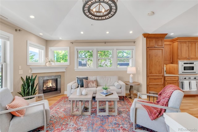 1824 Pearl St Unit B, Boulder, CO 80302 - living room with light wood-style floors, vaulted ceiling, recessed lighting, a glass covered fireplace, and a chandelier