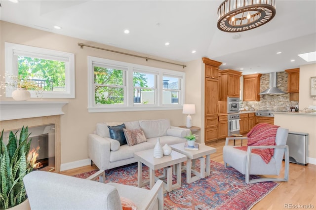1824 Pearl St Unit B, Boulder, CO 80302 - living room featuring light wood finished floors, a glass covered fireplace, recessed lighting, a chandelier, and vaulted ceiling