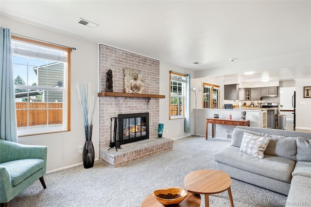 12945 E Colorado Ave, Aurora, CO 80012 - living room with visible vents, baseboards, light carpet, and a fireplace