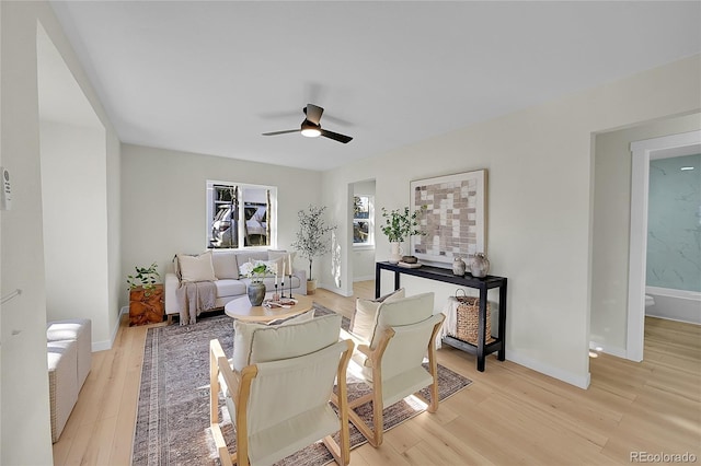 living room featuring ceiling fan and light hardwood / wood-style flooring