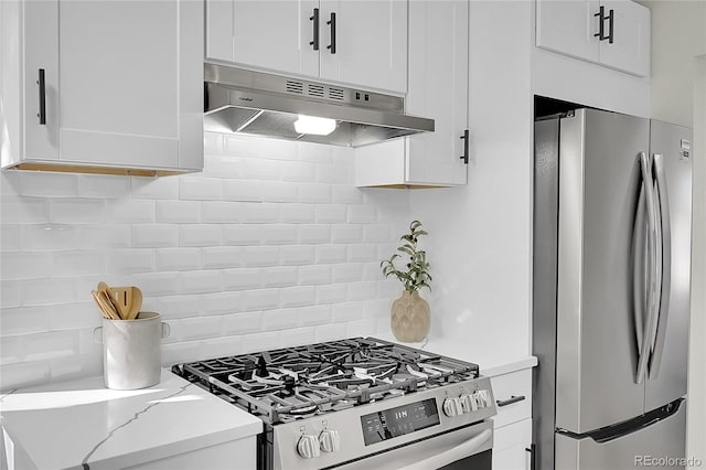 kitchen with white cabinets, decorative backsplash, light stone counters, and stainless steel appliances