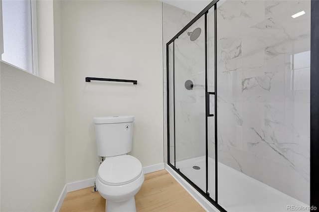 bathroom featuring toilet, a shower with shower door, and wood-type flooring