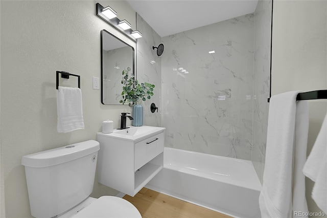 full bathroom with toilet, vanity, wood-type flooring, and tiled shower / bath