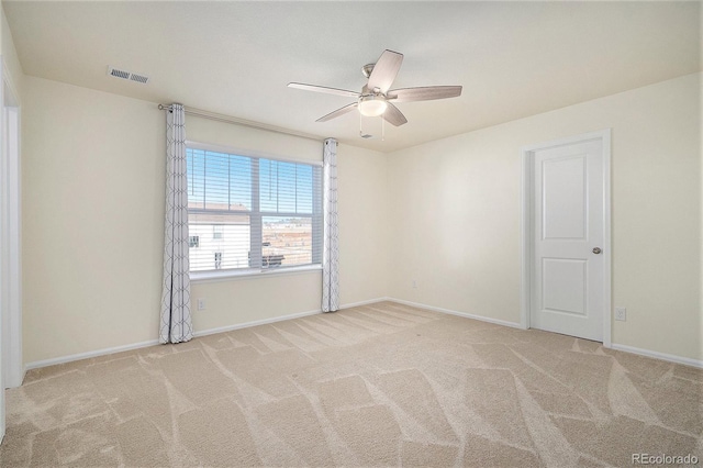 spare room with ceiling fan and light colored carpet