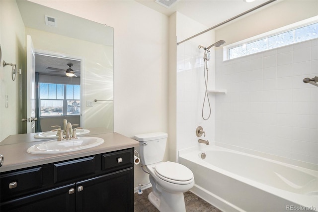 full bathroom with ceiling fan, vanity, tiled shower / bath combo, and toilet