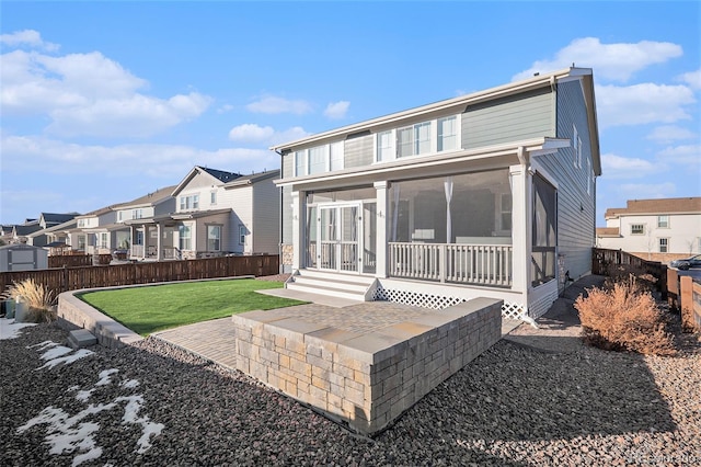 back of property featuring a lawn and a sunroom