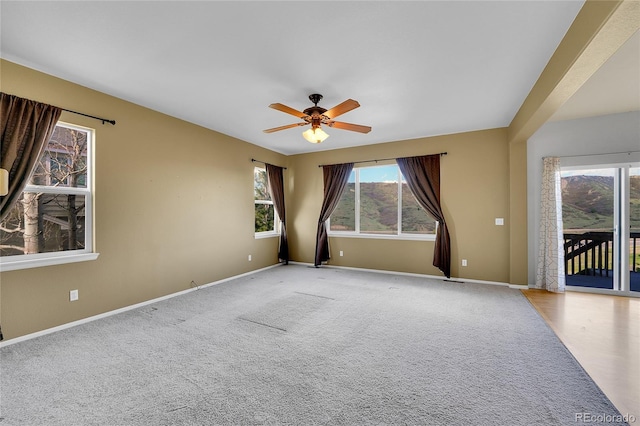 unfurnished room with baseboards, a ceiling fan, and light colored carpet