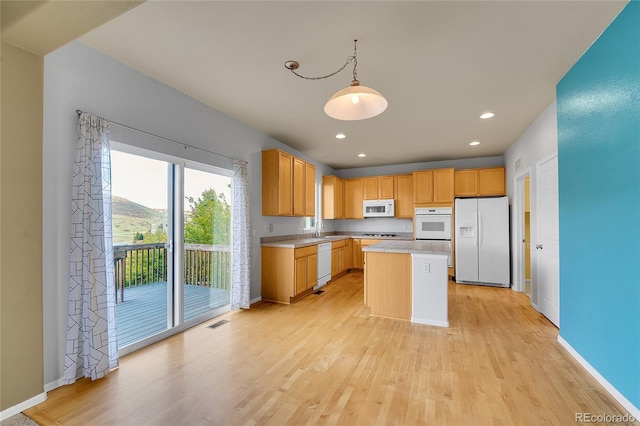 kitchen featuring white appliances, a sink, light wood-type flooring, light countertops, and recessed lighting