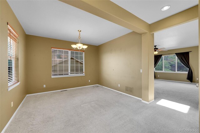spare room featuring carpet floors, a chandelier, baseboards, and a ceiling fan