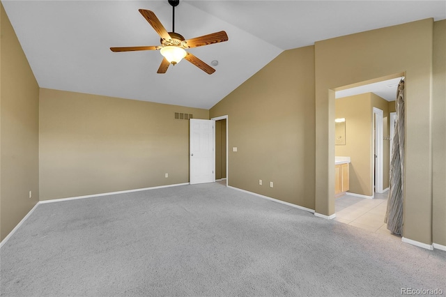 unfurnished bedroom with lofted ceiling, light colored carpet, baseboards, ceiling fan, and connected bathroom