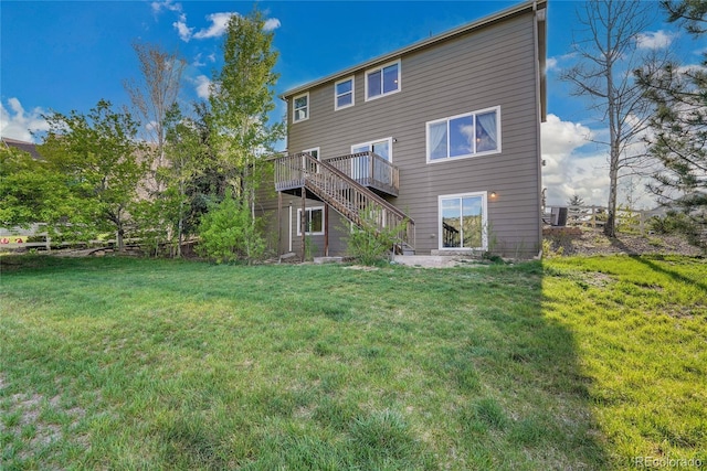 back of property with stairway, a lawn, and a wooden deck
