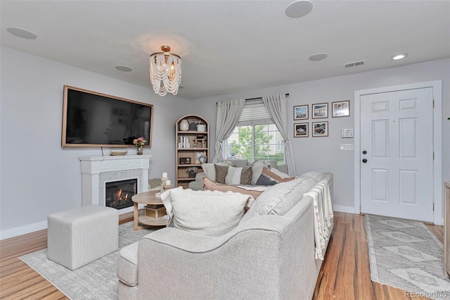 10042 Hudson St, Thornton, CO 80229 - living area featuring wood finished floors, a warm lit fireplace, baseboards, and recessed lighting
